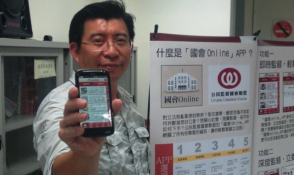 公督盟秘書長張宏林手持下載「國會online」APP的智慧型手機，希望明年底能夠達到10萬人下載的目標，將可以隨時監督立法委員的問政品質。圖:李雲深攝