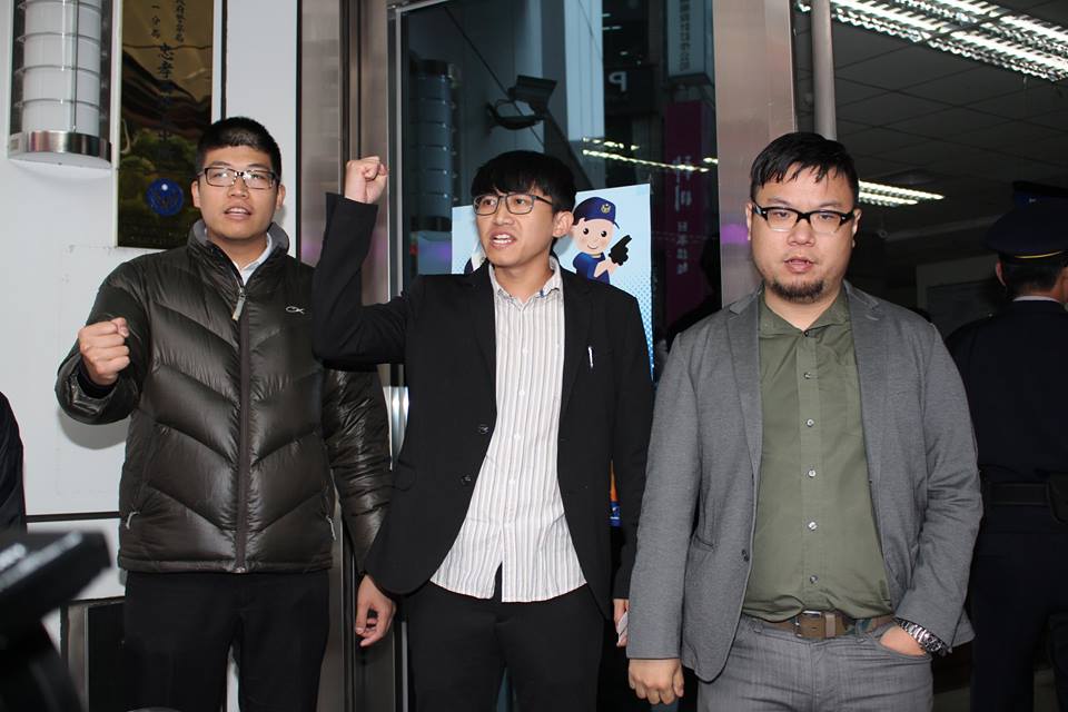 臺左維新總召林于倫（右）、成員李嘉宇（中）和律師詹晉鑒（左）高呼口號，走進中正一分局自首。圖：林雨佑/攝
