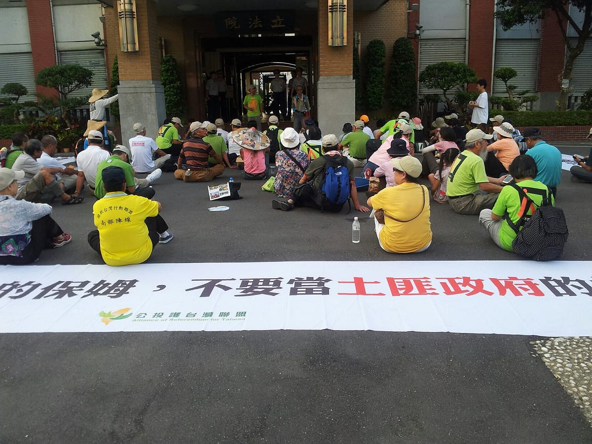 「公投護台灣聯盟」約100名示威民眾，今(29)日上午5時30分左右打開立法院鐵門，在立法院大門口廣場席地而坐。圖片2-2來源：台灣大地文教基金會的志工廖建超/攝，CC授權。