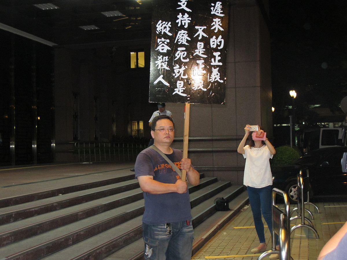 反對廢死民眾何守為5日手持「支持廢死就是縱容殺人」看板，在法務部前抗議廢死團體。圖：林朝億/攝