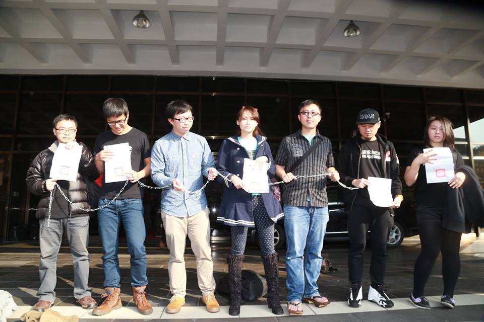 魏揚（左三）、賴品妤（左四）等被告在開庭前於台北地院門口，拿著鐵鍊高喊「大官來台，熱情款待」、「人民抗議，暴力對待」。圖3之1：林雨佑/攝