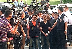 殺警案，台北市警察局19日持續追緝幫派分子萬少丞（前右3）等人，萬少丞下午5時許在律師陪同下到台北市刑大投案。圖：中央社