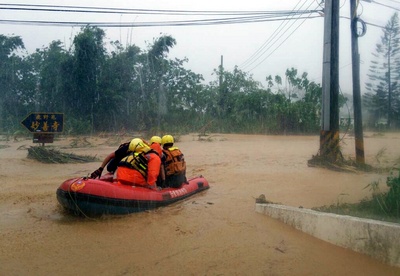 圖為21日台東延平鄉鸞山大橋下方防汛道路淹水，積水將近2公尺，3戶5人受困，情況危急，鹿野消防隊動員10餘名義消趕往救援。圖：中央社