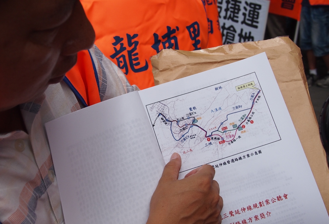 長期爭取捷運於介壽路設站的三峽礁溪里里長董耀琮，展示三鶯捷運的各個路線版本。圖:何星瑩/攝