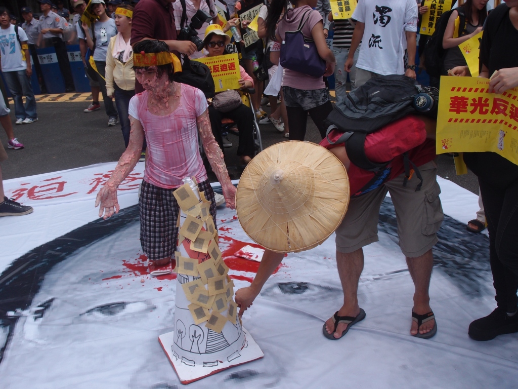 行動劇現場，聲援民眾輪流把冥紙貼在像徵高級住宅的標示上。圖：陳柔伊/攝