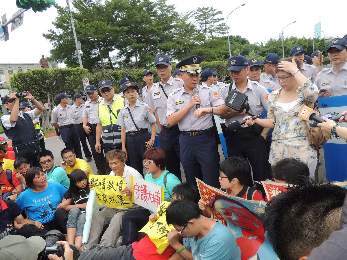 在獲知苗栗縣政府強拆大埔拒遷戶，農陣率領多名聲援者和居民坐在凱達格蘭大道中間怒喊，「官逼民反、抗爭有理」，警方已舉牌警告，目前已遭驅離。圖：林怡嫺/攝