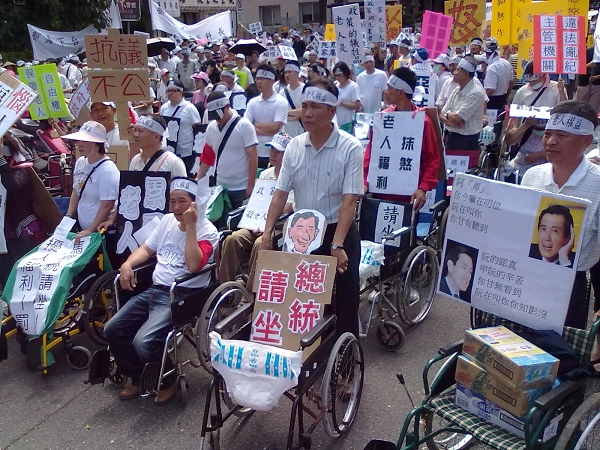 數百名老人、家屬、業者及工作者25日齊聚立法院對街、外交部前，抗議政府對待老人福利態度敷衍了事，要出動輪椅讓馬英九親自坐坐看。圖：賴義中/攝