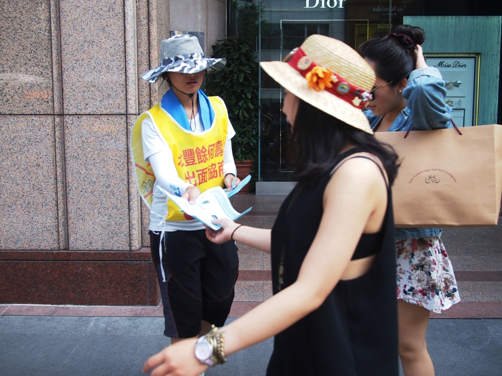 Hydis工人金慧仁在捷運中山站出口發送Hydis關廠事件宣傳單。圖:何星瑩/攝