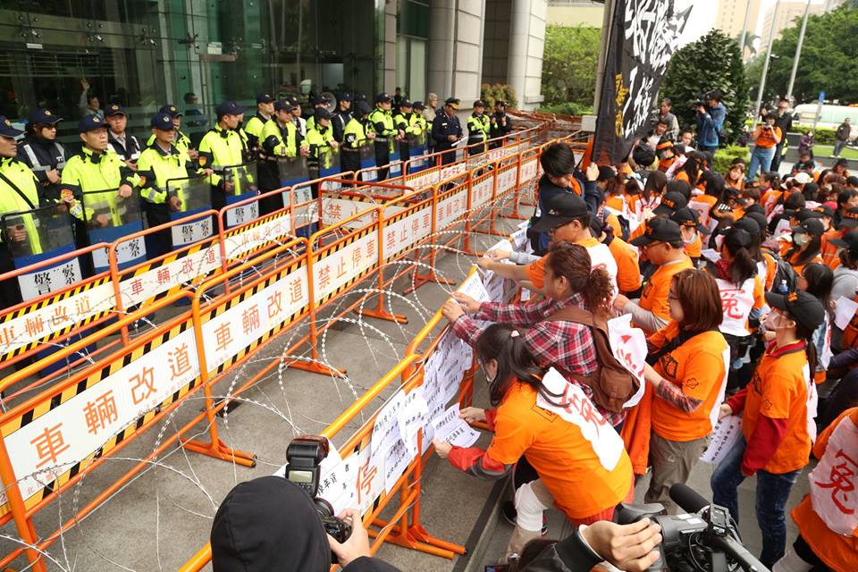 收費員每人手上高舉「約聘僱受害者＿ 被政府吃掉年資＿年」的標語，並寫上自己的名字和年資，貼在交通部前護欄上。圖：林雨佑/攝