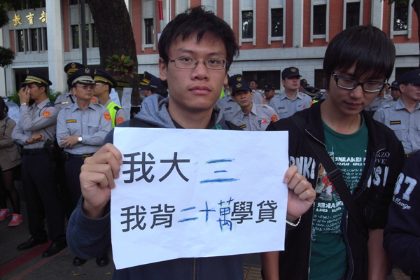 學生代表紛紛拿著自己積欠學貸的標語，呼籲教育部不要增加學生畢業後的債務負擔。圖：楊宗興/攝