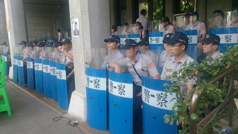 警察在教育部門口前，以盾牌形成一道人牆，在現場待命。圖：王子軒/攝