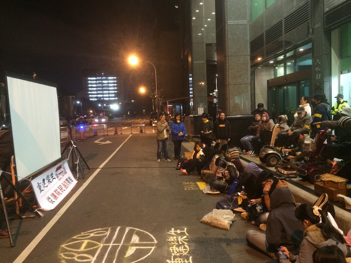 電影放映結束後，院民阿公、阿嬤以及聲援民眾，小心地點燃手上的蠟燭，將蠟燭放置在寫有「重建樂生」字樣地上。圖：楊淳卉/攝