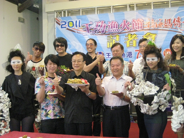 在「王功漁火節」的記者會現場，彰化縣長卓伯源及董事長樂團共同品嘗王功的蚵料理，兩旁的模特兒展示以蚵貝設計的服裝。圖片：徐佳宜/攝