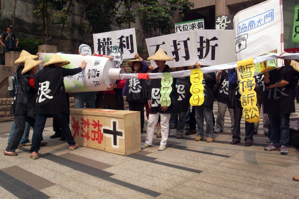 關廠工人在現場演出行動劇，他們拿出一條巨型牙膏，只見工人死命地擠這條牙膏，每擠一次才出現一個解決方案，諷刺勞委會在工人抗爭後才會提出方案。圖：楊宗興/攝