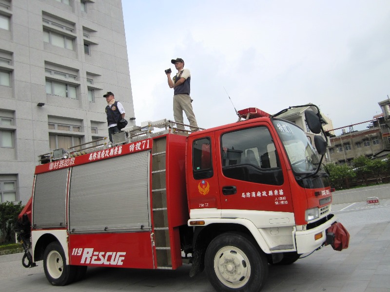 苗栗縣政府廣場上嚴陣以待的消防車，車上則有警察在錄影蒐證，圖5之4：王立柔/攝