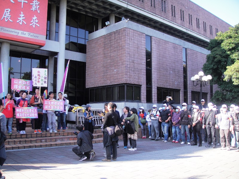 同志家庭權益促進會等團體今（30）天下午在國家圖書館前面召開記者會，表達異於凱道上「下一代幸福聯盟」正在主張的訴求，但整場記者會中約有50名戴著白帽及口罩、身上貼著「反修民法972」桃紅色標語牌的「下一代幸福聯盟」男性糾察，手牽手形成兩堵人牆連媒體記者一起「包圍」。圖4之1：王立柔/攝