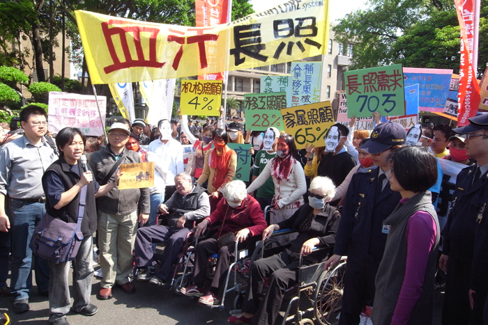 台灣國際移工聯盟等團體來到行政院前陳情，直指政府推動的長期照護制度無法解決外籍看護工血汗勞動的處境，他們將陳情書遞給行政院代表。圖：楊宗興/攝