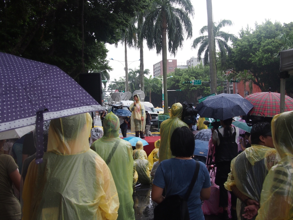 22日下午4點多，現場下起大雨，主辦單位立即發送雨衣給現場民眾，民眾紛紛穿上雨衣，繼續於現場守候。圖:何星瑩/攝