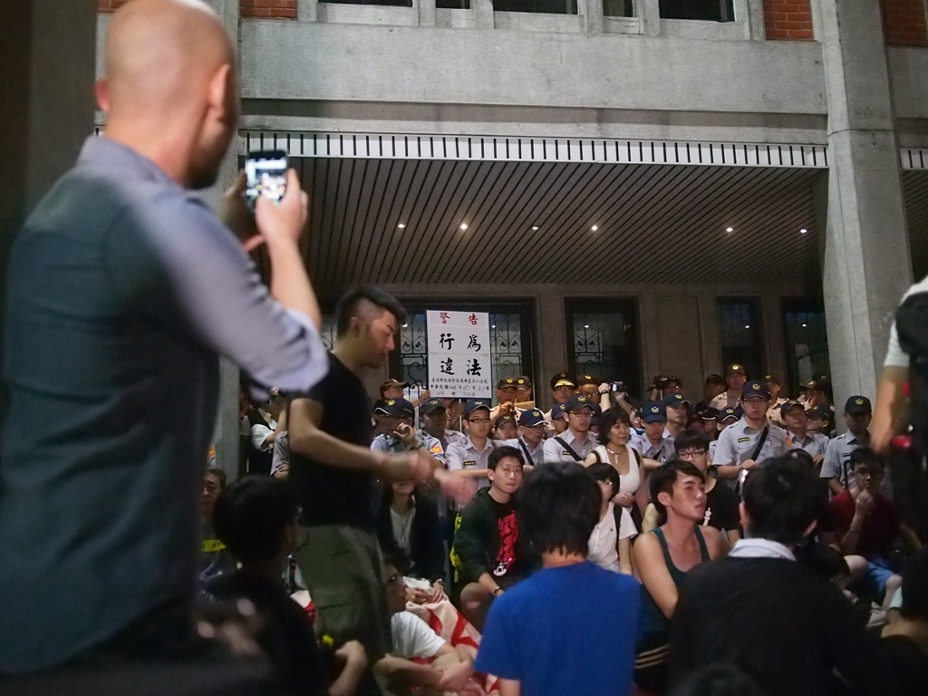 反課綱學生與支持群眾31日凌晨衝入教育部，並有約300人於中庭靜坐，4點時警方進行第1次舉牌，之後隔15分鐘進行2、3次舉牌警告。圖:何星瑩/攝
