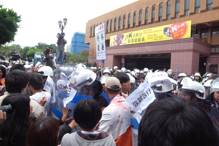 在法務部沒有任何官員出面接受陳情的情況下，居民則將手中寫著「強制執行」的標語，打算貼在法務部門口的圍牆上，卻與警方發生激烈推擠衝突。圖：楊宗興/攝
