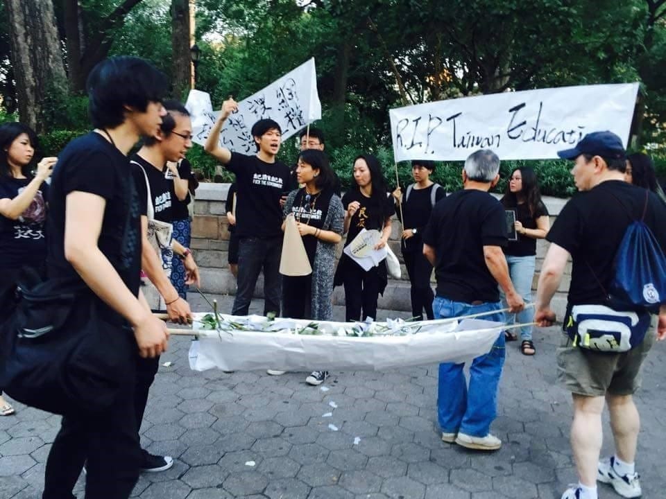 北美台灣留學生發起聲援反課綱活動，紐約場學生穿黑衣拿標語、點蠟燭，並拿白花弔念林冠華，並將花放在做好的擔架上，就像國外喪禮會把花放在死者身上一樣。圖：讀者提供