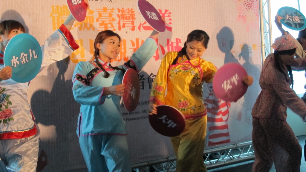 交通部觀光局與台北101今（27）日舉行「體驗台灣之美、遇見觀光小城」特展的剪綵儀式，舞者手拿代表小城的牌子，配合「小城故事」起舞。圖：武陵/攝。