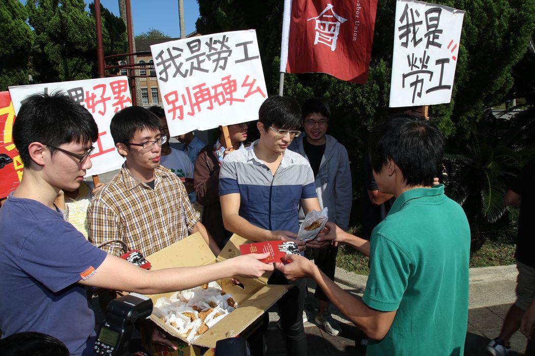 台大工會慶祝助理與台大確定雇傭關係的判決勝訴，工會秘書林凱衡（左二）履行承諾今日早(8)上於傅鐘前請吃150塊雞排，感謝大家的支持。圖：林雨佑/攝。