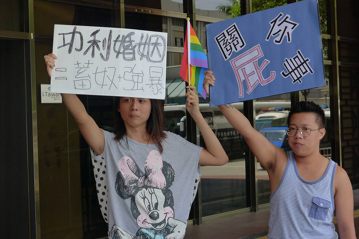 支持同性伴侶法的民眾吳馨恩(左)，也到場舉標語，和平表達自己的意見。圖：陳毅龍/攝
