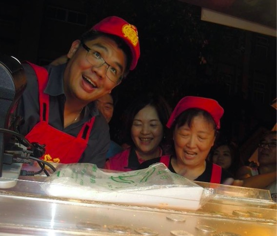 民眾持悠遊卡在夜市刷卡消費是國民黨台北市長候選人連勝文去年提出的政見，圖為連勝文去年至寧夏夜市潤餅攤和攤商一同學做潤餅。圖：新頭殼資料照片