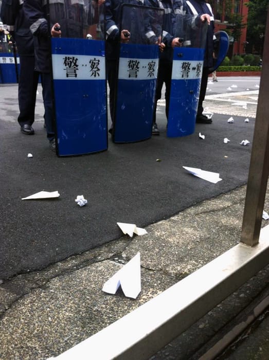 反媒體巨獸青年聯盟今天在立院前上演「丟紙飛機」的行動，是這個國家最荒謬的場景之一，看著立院牆內的警察，用鎮暴用的盾牌擋著紙飛機的「進攻」，實在令人覺得可悲。圖片來源：楊宗興/攝