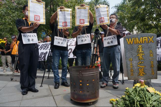大同電信連同多家電信業者今（3）日於國家通訊傳播委員會（NCC）抗議。現場立起WiMAX產業之墓，播放輓歌，讓所有在場員工依序獻上菊花，甚至燒起冥紙以及過去NCC所發放的「無線寬頻接取業務特許執照」，場面十分哀戚。圖2之1：張容瑄/攝