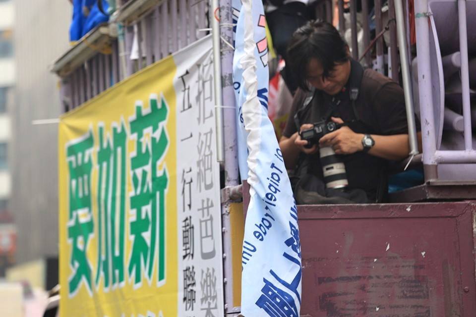 記者長時間勞動的情形必須改善。圖為51勞動節遊行，攝影記者在宣傳車上拍照的工作情形。圖：林雨佑/攝