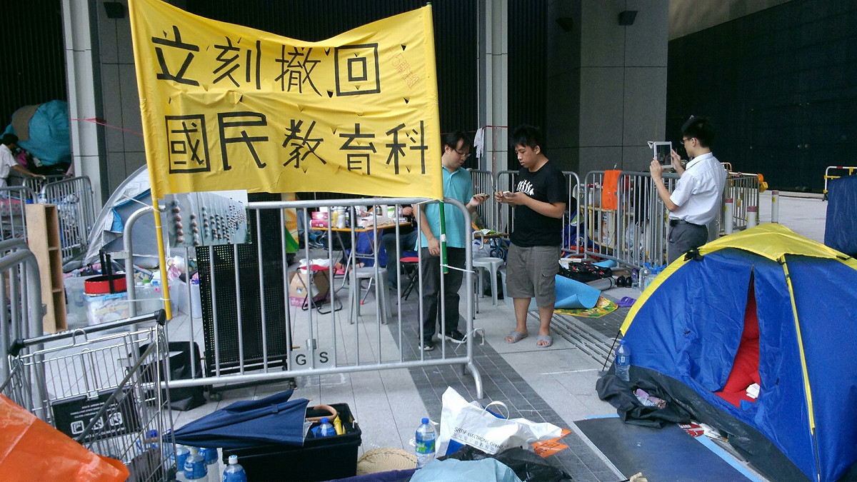 香港政總廣場，仍有數10名人士堅守不願離開，他們訴求不可讓反洗腦運動的熱潮中斷。圖：呂家睿/攝。