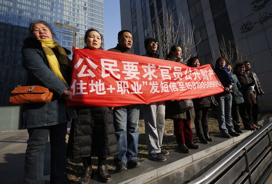 日前許志永發起的「新公民運動」被控「聚眾擾亂公共場所秩序罪」，支持者於法庭外拉布條抗議。（資料照片） 圖：達志影像 / 路透社