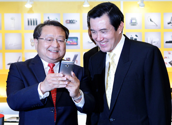 HTC亞洲區營運副總經理張佳欽(左)為總統馬英九介紹HTC新One手機，這款手機獲得台北國際電腦展創新設計獎最高殊榮金質獎。圖片來源：宏達電提供