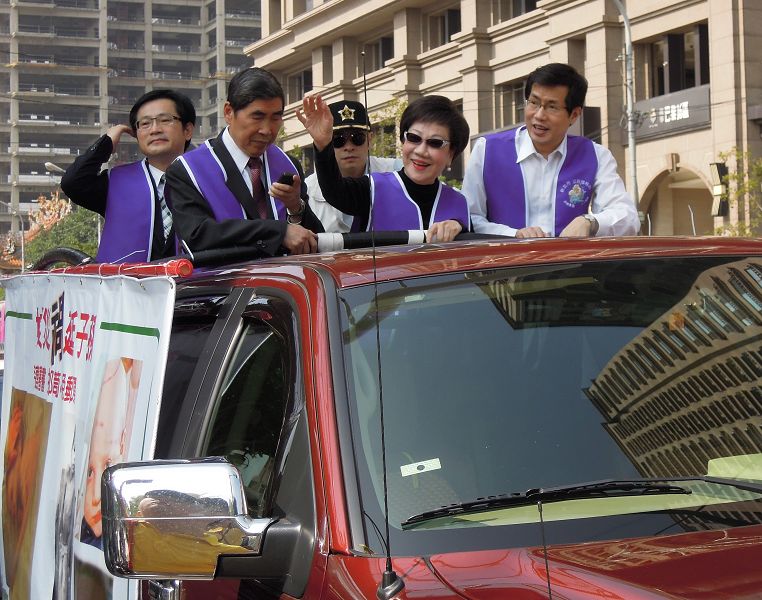 前副總統呂秀蓮宣傳公投反核四的車隊，從板橋第一運動場出發到大街小巷宣傳，呂秀蓮並站在的車隊上，頻頻向民眾揮手尋求認同與支持。圖：陳冠廷/攝