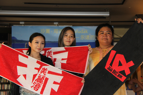 歌手飛（Faye，左）、張懸（中）及巴奈（右）共同出席杉原海灘年度音樂晚會記者會，手持反美麗灣渡假村毛巾進行合影。圖：賴義中/攝。