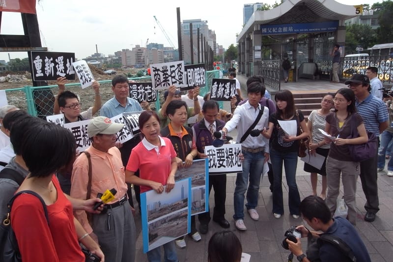 十幾名松山菸廠附近居民、里長在林奕華的帶領下，12日上午在捷運國父紀念館站出口的大巨蛋工地旁召開記者會，表達反對興建大巨蛋的訴求。圖片：楊宗興/攝