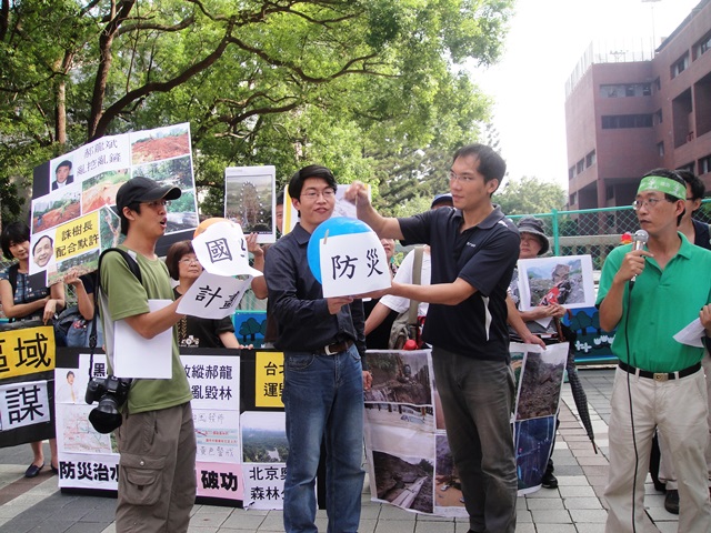 環保團體上演行動劇，戳破手中寫著「防災」、「治水」、「國土計畫」的彩色氣球。圖2之2：王立柔/攝