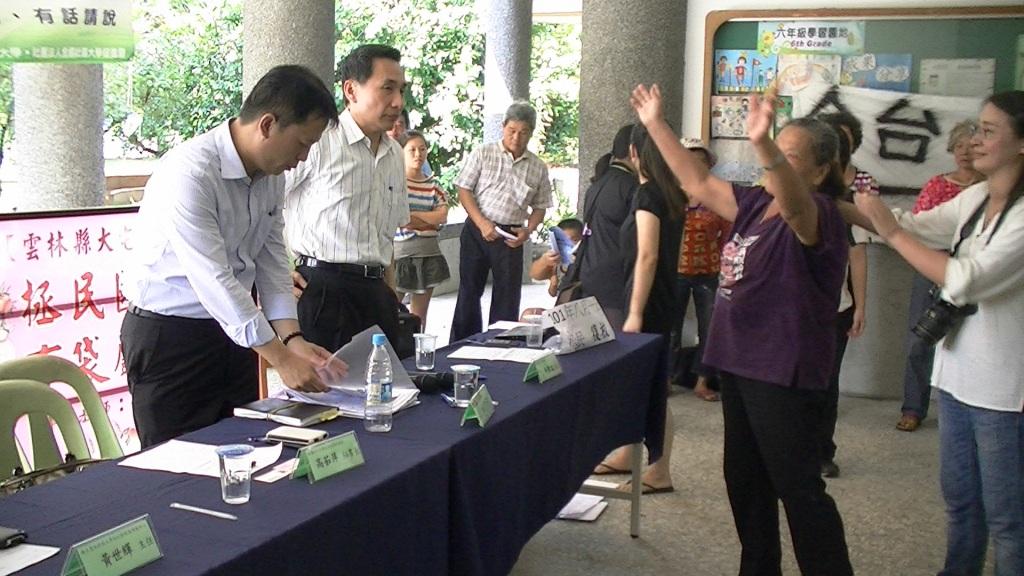 雲林虎尾拯民國小18日舉行公民論壇，針對藝術學校進駐拯民國小產生的衝擊進行官民對話，結束前，虎尾阿嬤(舉手者)一度下跪，並拜託縣府放手，讓副縣長施克和(左一)連忙起身，十分尷尬。圖：莊豐嘉攝影