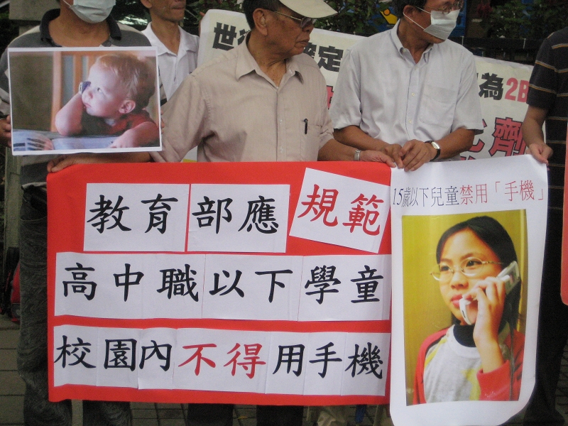 台灣電磁輻射公害防治協會等環保團體，今（19）日上午陪同家長代表前往教育部前召開記者會，要求政府立法規範15歲以下的兒童及少年在校園內禁用手機。圖片：徐佳宜/攝