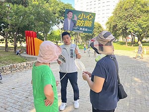 時事手舉牌力抗對手看板海 簡嘉佑：本人就在你面前