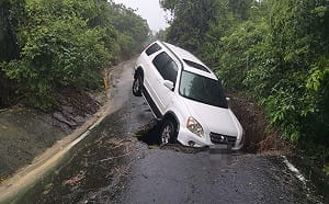 高雄豪雨狂灌！岡山路基掏空現天坑 休旅車受困險摔邊坡