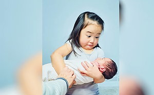 第一次抱剛出生的妹妹　女童表情超母湯：怎麼那麼重