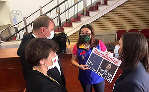 陳玉珍持自製字卡向捷克議員示意：「國民黨拒絕瘦肉精豬肉進口！」