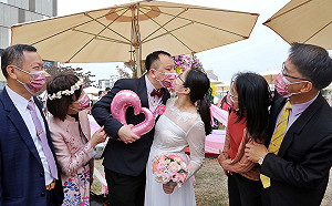 疫情擋不住的愛  嘉市集團結婚新人戴口罩接吻