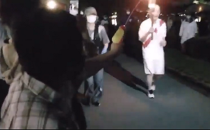 (影) 高喊反奧運口號 日本大嬸用水槍噴火炬手 遭現場逮捕