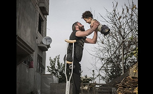 1張照片說明敍利亞！獨腳難民爸抱無四肢兒舉高高