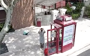 詭異 她住在上海紅色電話亭裡!  保全：已一年多 還拖行李箱帶著一條狗