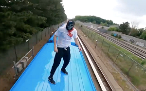 加拿大兩男子爬上行駛列車「衝浪」 車頂舉國旗